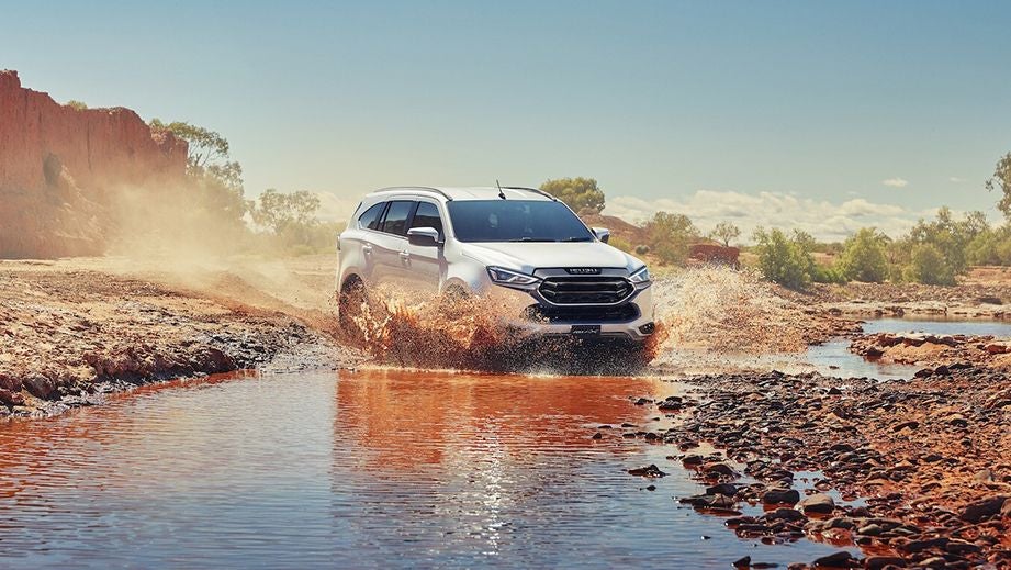 front view of a Isuzu MU-X driving through water