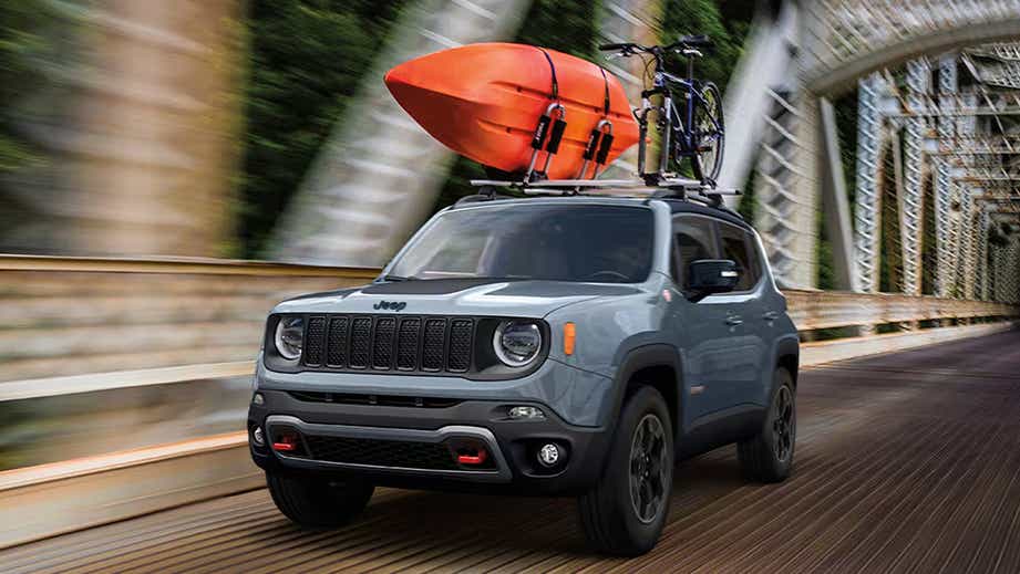 front three-quarter view of a Jeep Renegade with a kayak and bike mounted on the roof