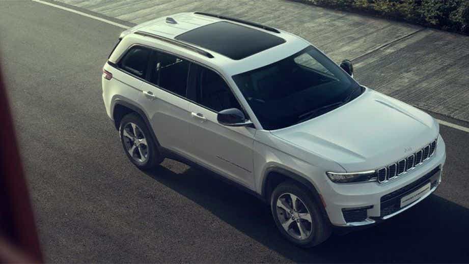high-angle front three-quarter view of a Bright White Jeep Grand Cherokee