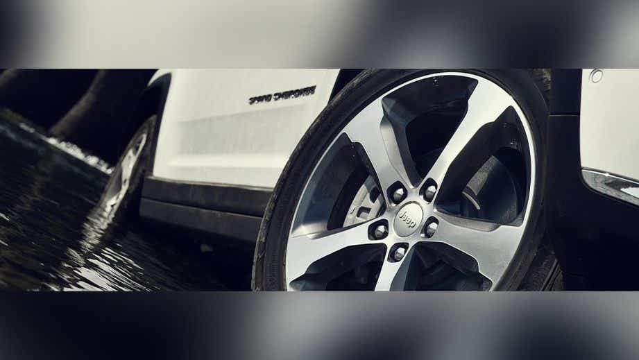 front wheel close-up of a Bright White Jeep Grand Cherokee
