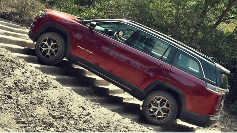 side view of a Jeep Meridian 2022-2023 ascending steps outdoors