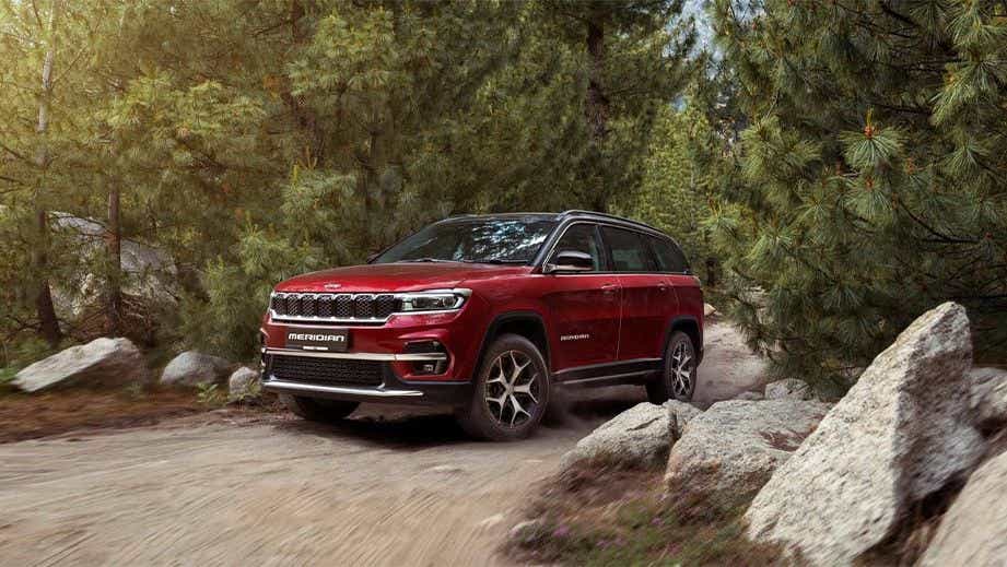 front three-quarter view of a Jeep Meridian 2022-2023 on a forest trail