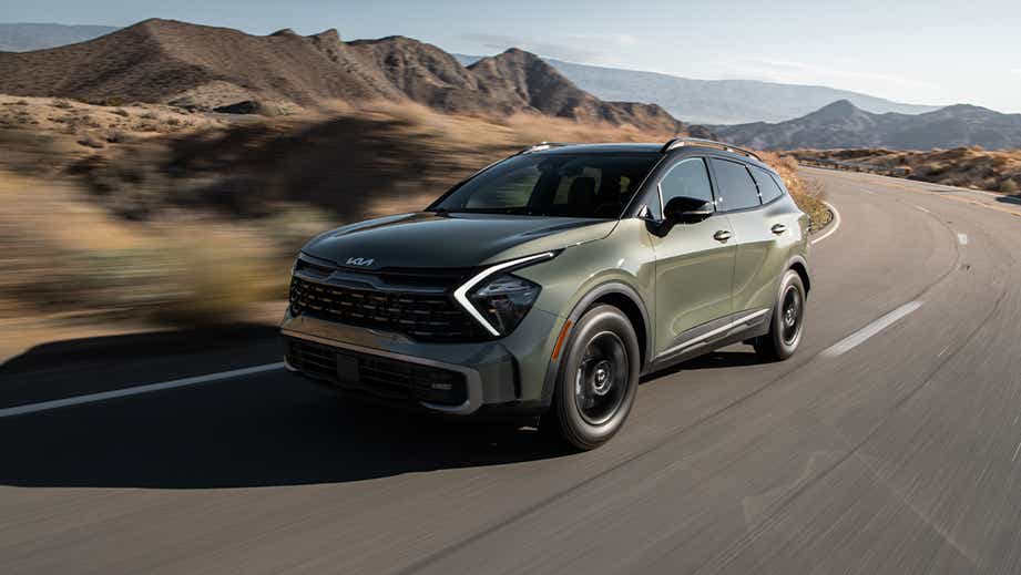 Front three-quarter view of a Kia Sportage driving on a mountain road