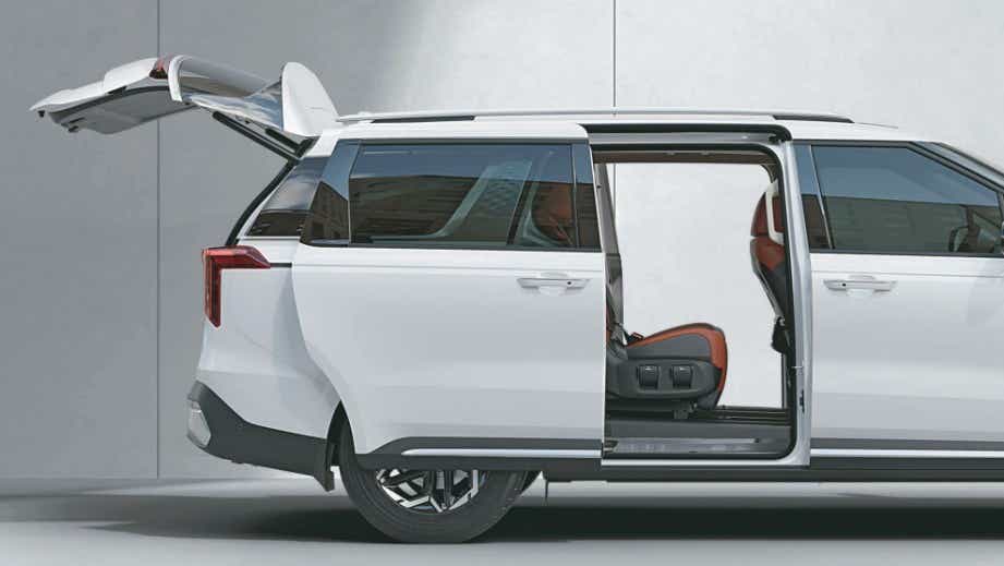 side view with open sliding door and boot of a Glacier White Pearl Kia Carnival