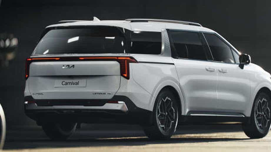 rear three-quarter view of a Glacier White Pearl Kia Carnival