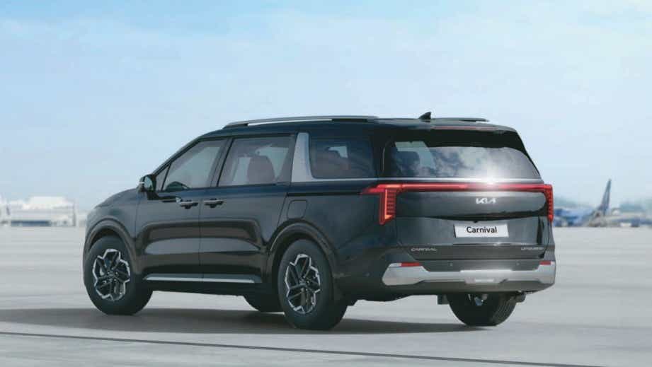 rear three-quarter of a Fusion Black Kia Carnival