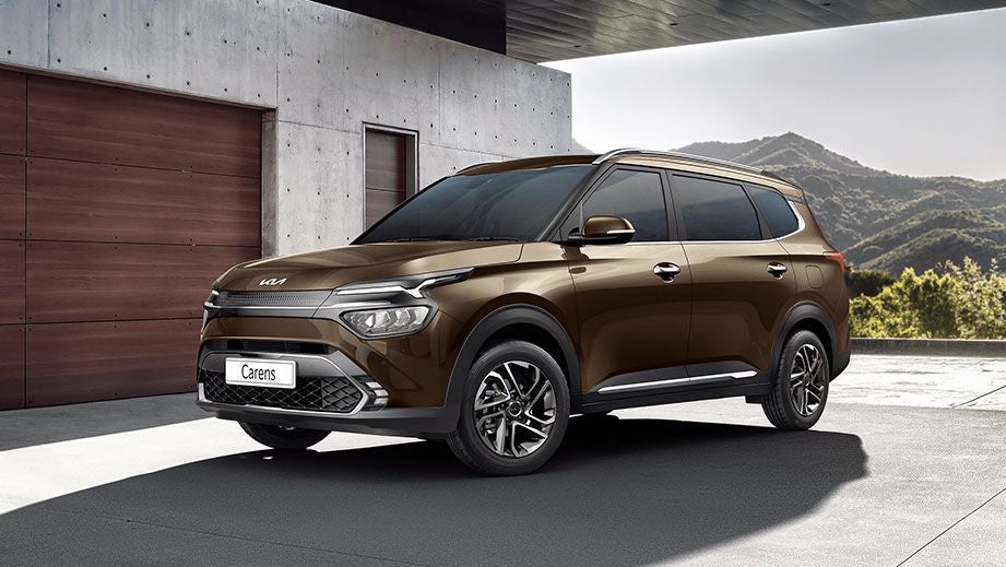 front three-quarter view of a Moss Brown Kia Carens