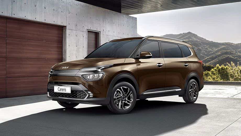 front three-quarter view of a Moss Brown Kia Carens