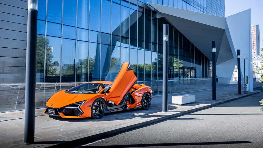 Front three-quarter view of a Arancio Apodis Lamborghini Revuelto with doors open