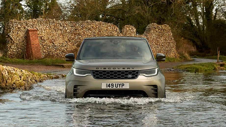 front view of a Land Rover Discovery driving through water