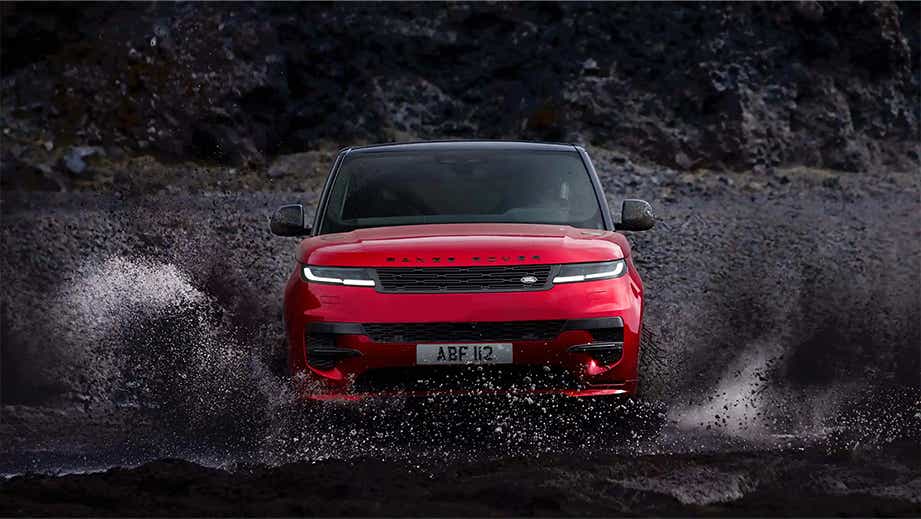 Front view of a Land Rover Range Rover Sport driving through water splash