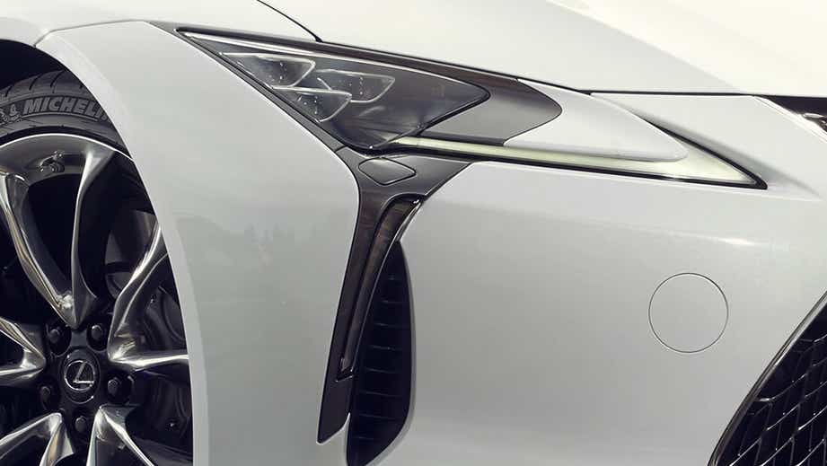 Front wheel and headlight close-up of a White Nova Glass Flake Lexus LC 500h
