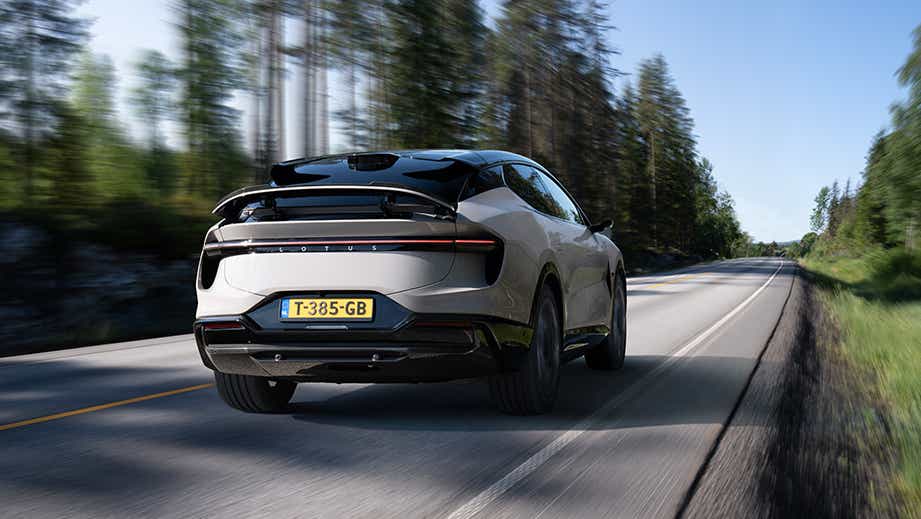rear view of a Lotus Eletre driving on a scenic forest road