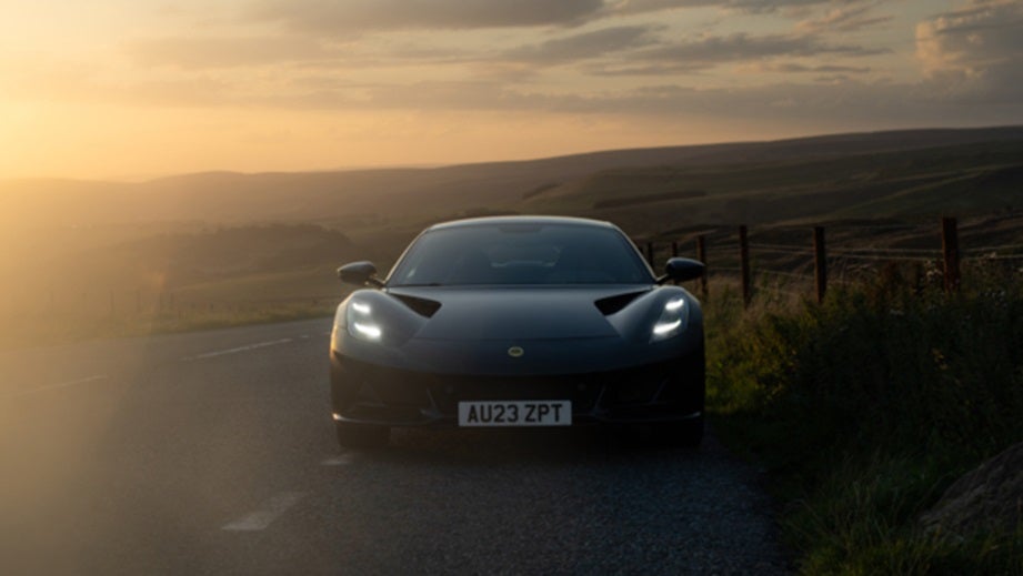 front view of a Lotus Emira on a country road at sunset