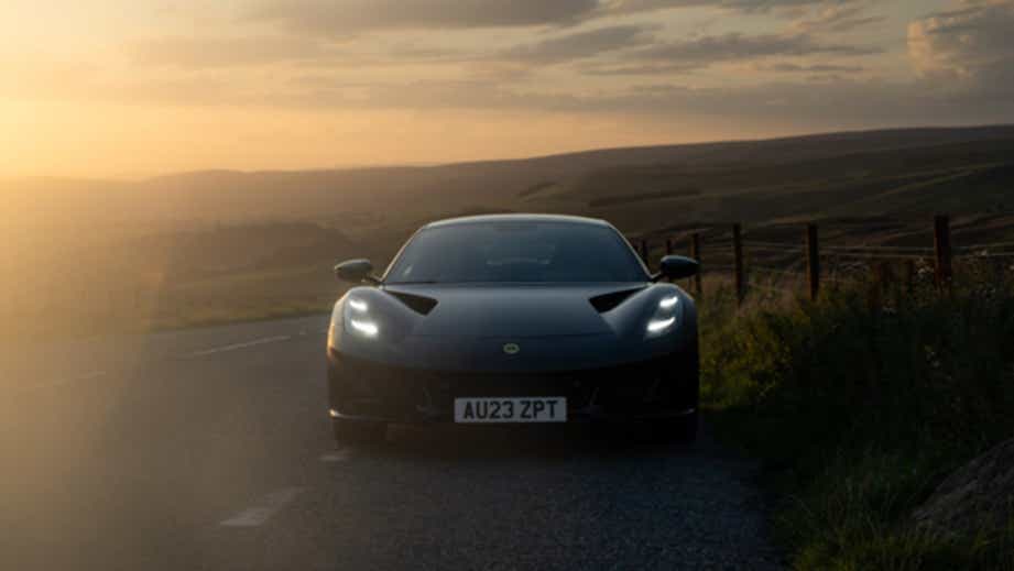 front view of a Lotus Emira on a country road at sunset