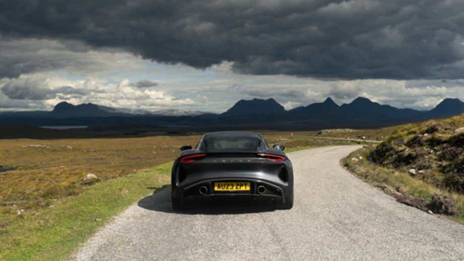 Rear view of a Lotus Emira on a scenic winding road