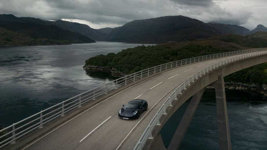 overhead view of a Lotus Emira driving on a scenic bridge