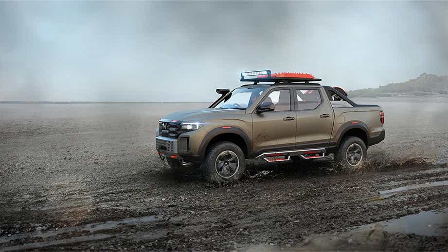 side view of a Mahindra Global Pik Up driving on muddy terrain