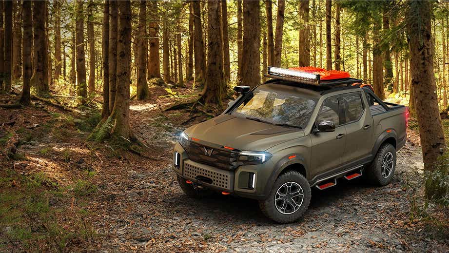 front three-quarter view of a Mahindra Global Pik Up in a forest