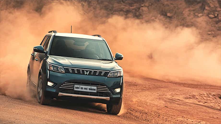 front view of a Mahindra XUV300 driving on a dirt road