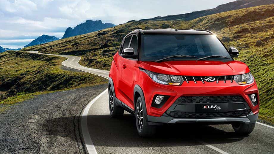 Front three-quarter view of a Flamboyant Red Mahindra KUV 100 NXT