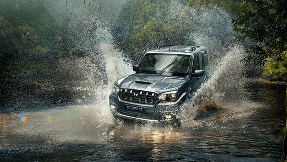 front view of a Mahindra Scorpio Classic splashing water outdoors