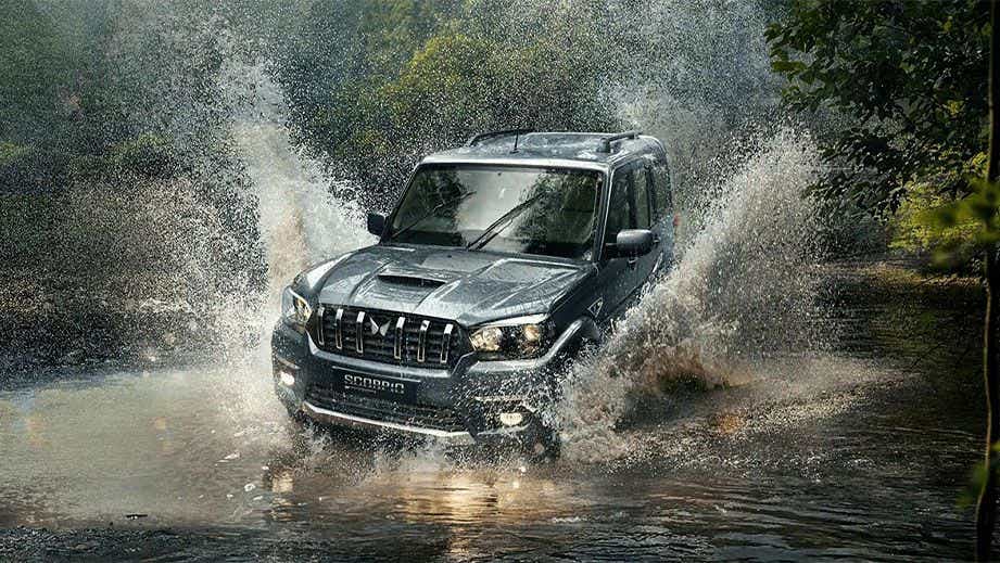front view of a Mahindra Scorpio Classic driving through water splashes
