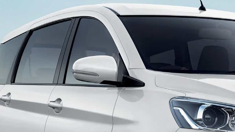 Front side view of a Pearl Arctic White Maruti Suzuki Ertiga Tour