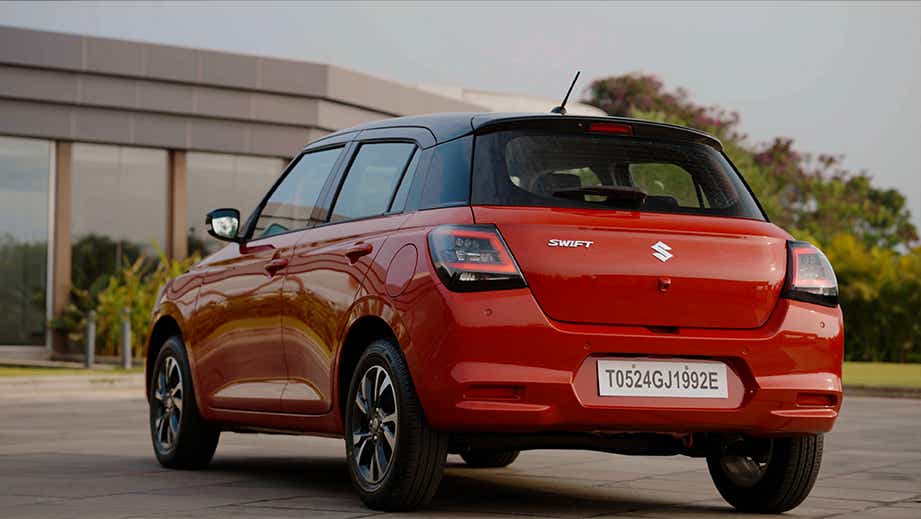 rear three-quarter of a Sizzling Red with Midnight Black Maruti Suzuki Swift