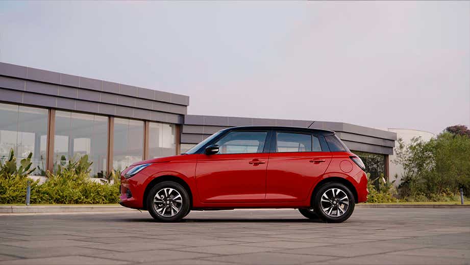 side view of a Sizzling Red with Midnight Black Maruti Suzuki Swift