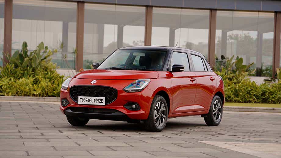 front three-quarter of a Sizzling Red with Midnight Black Maruti Suzuki Swift