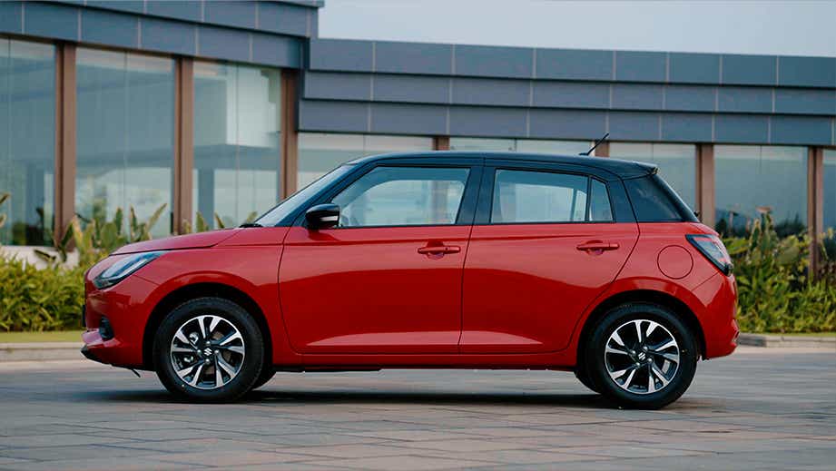 side view of a Sizzling Red with Midnight Black Maruti Suzuki Swift