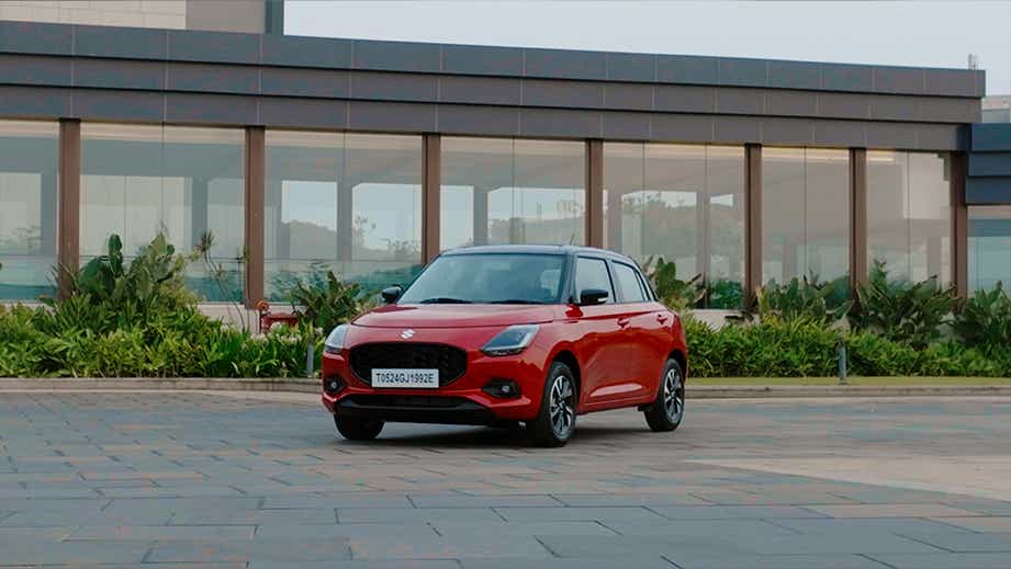 front three-quarter view of a Sizzling Red with Midnight Black Maruti Suzuki Swift