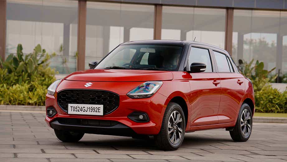 Front three-quarter view of a Sizzling Red with Midnight Black Maruti Suzuki Swift