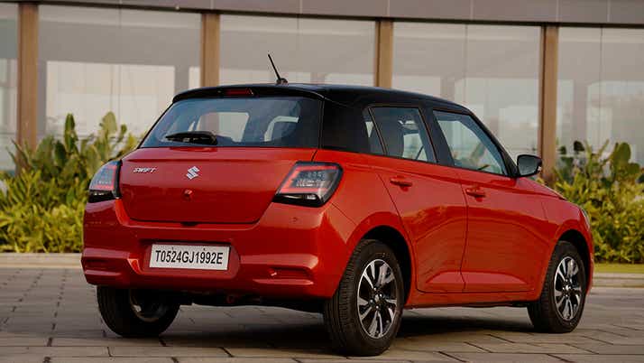 Rear three-quarter of a Sizzling Red with Midnight Black Maruti Suzuki Swift