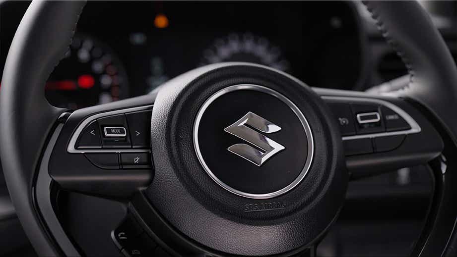 Steering wheel and controls of a Maruti Suzuki Swift
