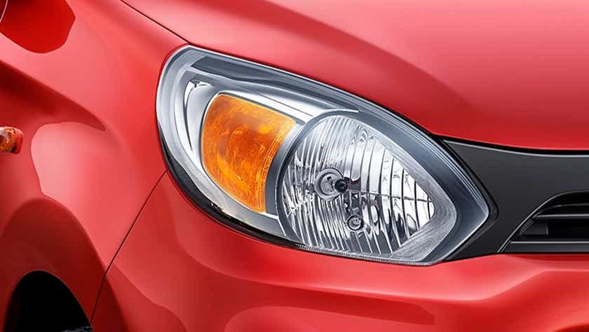 Headlight close-up of a Uptown Red Maruti Suzuki Alto