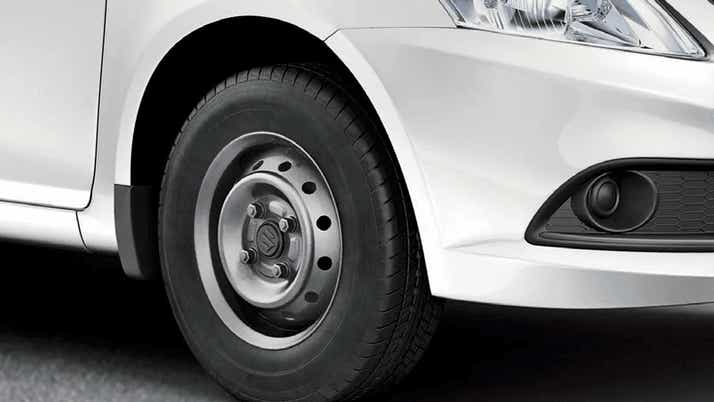 Front wheel and headlight area of a Maruti Suzuki Dzire Tour