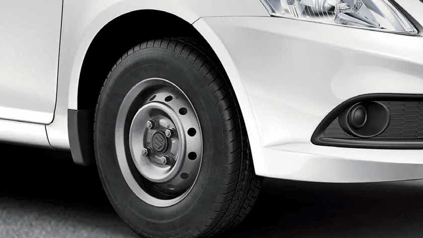 Front wheel and headlight area of a Maruti Suzuki Dzire Tour