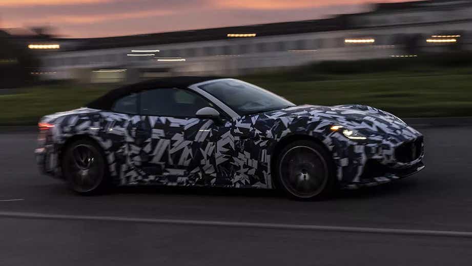 side view of a Maserati GranCabrio convertible driving on a road