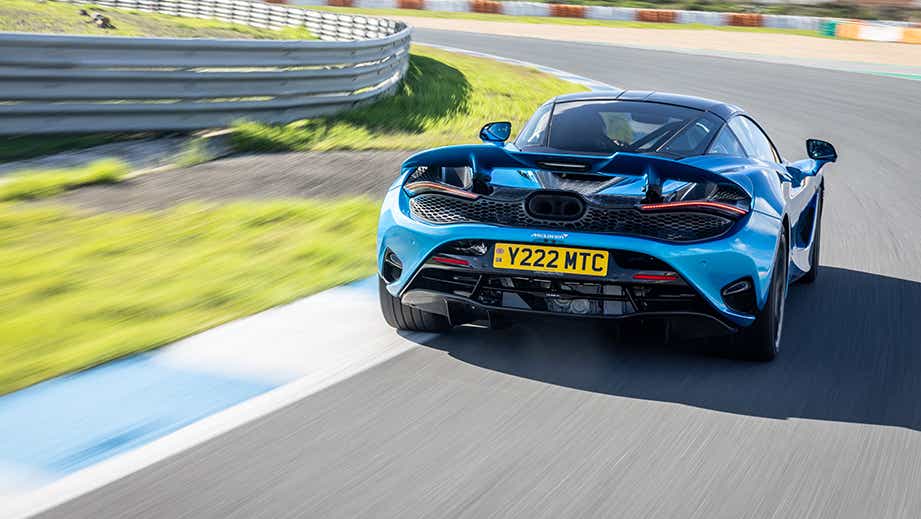 rear view of a Aurora Blue Mclaren 750s on a racetrack
