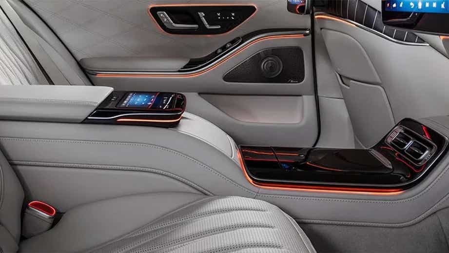 Rear seat and armrest console interior of a Polar White Mercedes-Benz AMG S 63