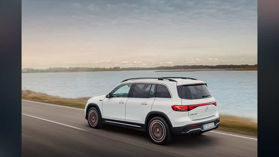 rear three-quarter view of a Mercedes-Benz EQB 2022-23 driving by a lake