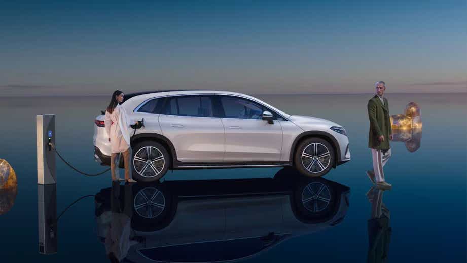 side view of a Mercedes-Benz EQS SUV being charged outdoors