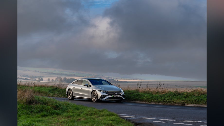front three-quarter view of a Mercedes-Benz EQS on a rural road
