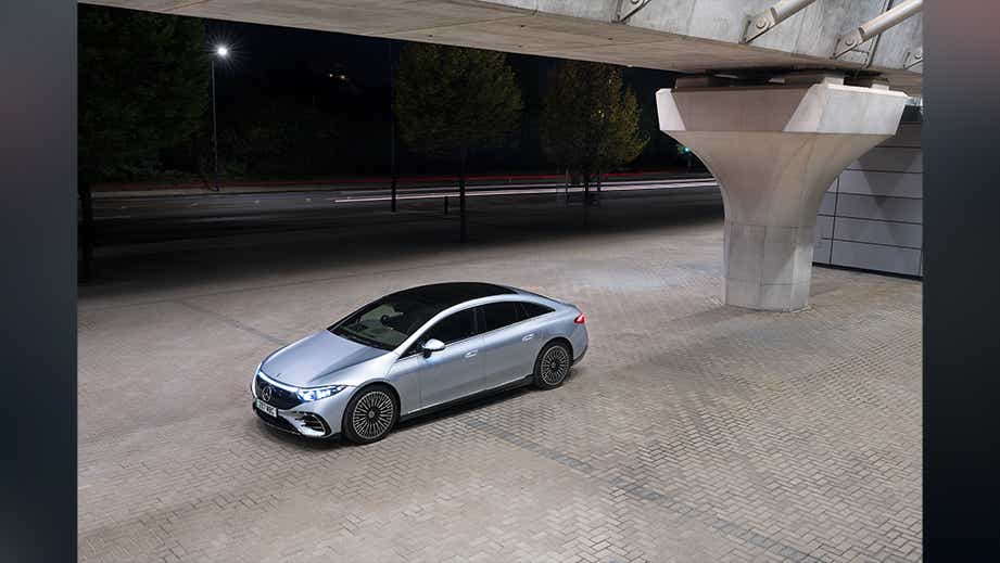 full-car view of a Mercedes-Benz EQS under a bridge at night