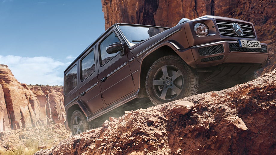 side view of a Mercedes-Benz G-Class driving off-road in a canyon
