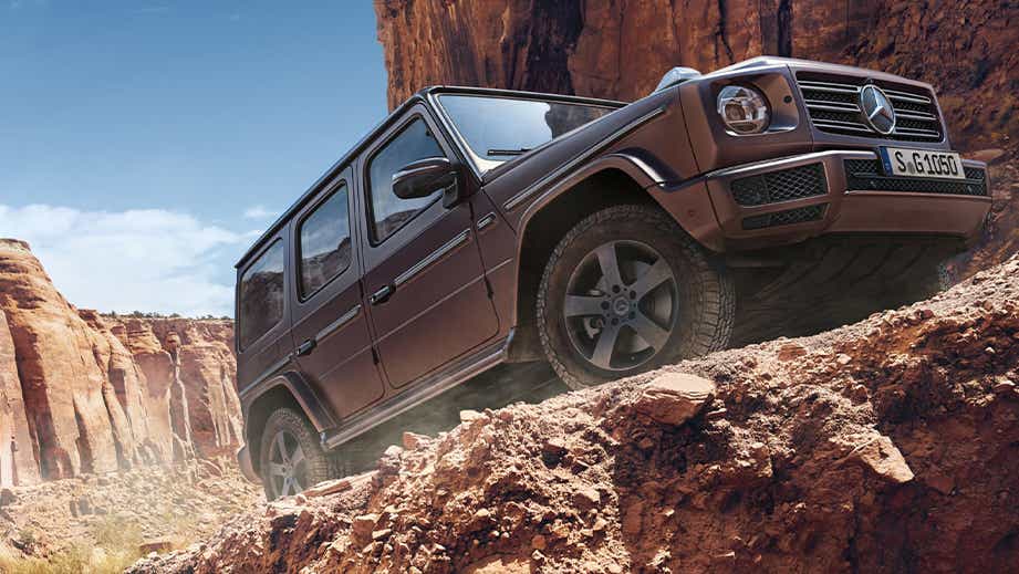 side view of a Mercedes-Benz G-Class driving off-road in a canyon