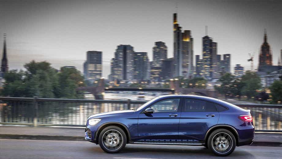 side profile of a Mercedes-Benz GLC Coupe with city skyline background