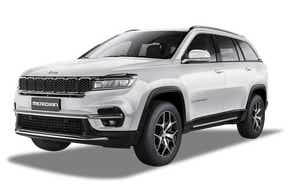 front three-quarter view of a Pearl White Jeep Meridian